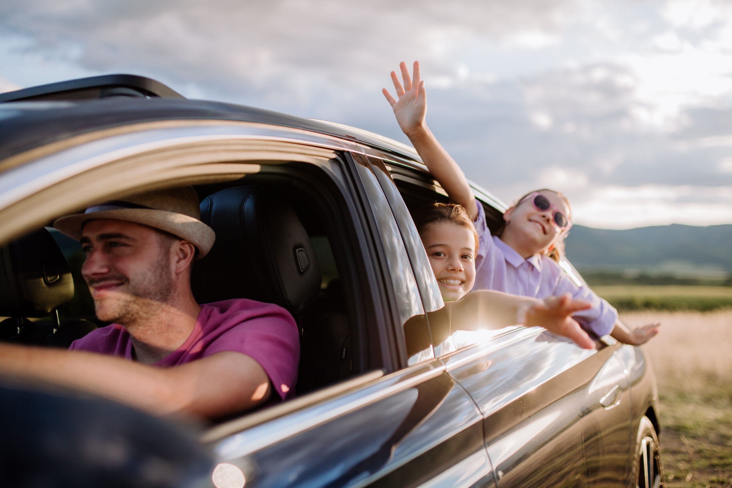 Happy family enjoying drive in their new electric car.